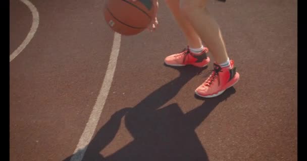 Closeup portrait of young attractive caucasian male basketball player throwing a ball in the hoop on the court outdoors in the summer — Stock Video