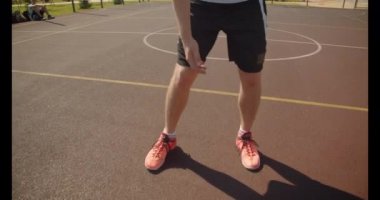 Genç çekici beyaz erkek basketbolcu arka planda cityscapes ile sahada pota bir top atma Closeup portre