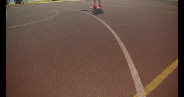 Close-up portret van jonge actieve Kaukasische mannelijke basketbalspeler gooien een bal in de hoepel op de baan in het Park — Stockvideo