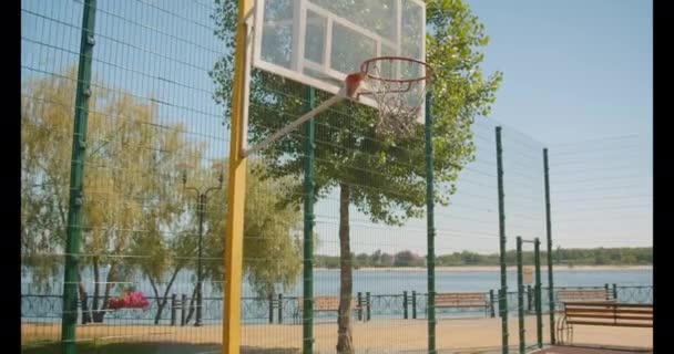 Портрет крупным планом баскетбольного кольца на корте на открытом воздухе в городе — стоковое видео