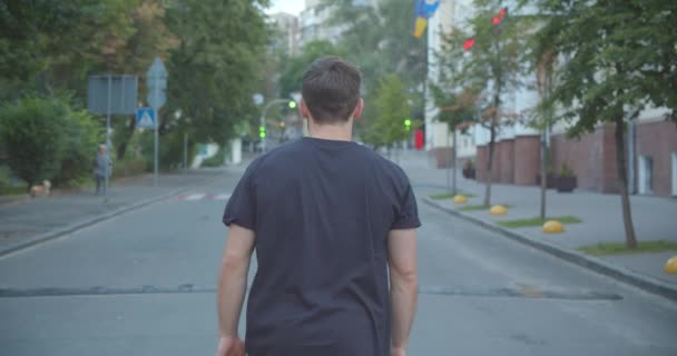 Nahaufnahme Porträt eines erwachsenen kaukasischen athletischen männlichen Joggers, der die Straße in der Stadt im Freien hinunterläuft — Stockvideo