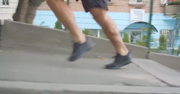 Gros plan vue de côté portrait d'un coureur masculin sportif déterminé à monter les escaliers dans la rue à l'extérieur de la ville urbaine — Video