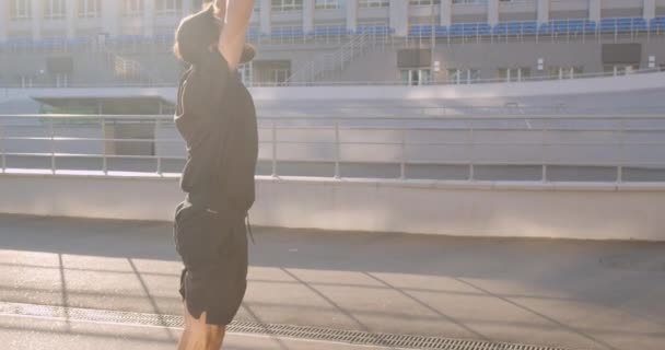 Крупный план портрета взрослого кавказского спортивного бегуна, протягивающего руки на стадионе в городском городе на открытом воздухе — стоковое видео