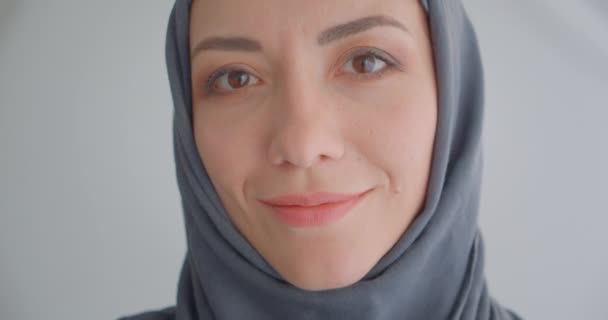 特写肖像的年轻有吸引力的穆斯林妇女在头巾看着相机微笑欢快与背景孤立在白色 — 图库视频影像