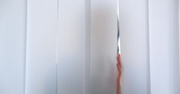 Closeup portrait of young muslim woman in hijab looking looking at camera hiding behind tulle indoors in apartment — Stock Video