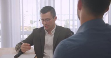İki çekici işadamının kapalı ofiste iş görüşmesi yaptığı closeup portresi