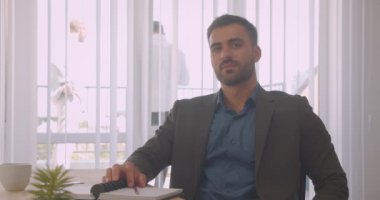 İşyerinde ofis kapalı kamera bakarak çekici kendinden emin işadamı closeup portre