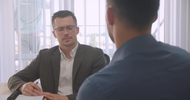 Retrato de close-up de dois empresários atraentes que têm uma entrevista de emprego no escritório dentro de casa no local de trabalho — Vídeo de Stock