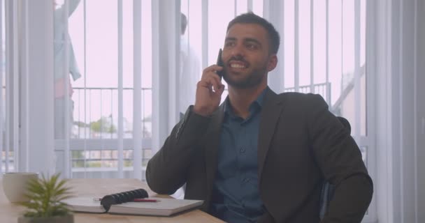 Retrato de close-up de empresário atraente ter um telefonema no escritório dentro de casa no local de trabalho — Vídeo de Stock