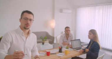 Ofiste kapalı alanda birlikte çalışan üç collleague'in portresi. Ekranda fikir yazan işadamı