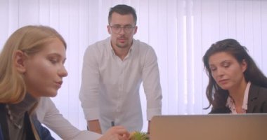 Ofis kapalı dört collleagues toplantı portresi. İş adamları dizüstü bilgisayar kullanarak ve işyerinde konuşma çözme sorunu yaşıyor