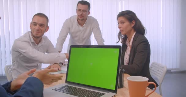 Portret czterech spotkań colllig w biurze w pomieszczeniu. Ludzie biznesowi przy użyciu laptopa z zielonym ekranem chrominancji i dyskusji — Wideo stockowe