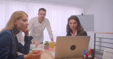 Ofis kapalı dört collleagues toplantı portresi. İş adamları dizüstü bilgisayar kullanarak ve işyerinde bir tartışma
