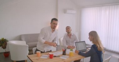 Ofiste kapalı alanda birlikte çalışan üç collleague'in portresi. İşadamı ekrana yazı yazıyor