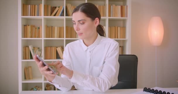 Tableti kullanan ve ofiste kameraya yeşil renk anahtar ekranı gösteren genç çekici kafkas iş kadınının yakın çekim portresi — Stok video