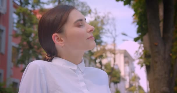 Park açık havada mutlu bir şekilde dinlenen genç çekici beyaz iş kadınının closeup portresi — Stok video
