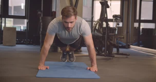 Gros plan portrait de l'homme caucasien attrayant adulte faisant push ups dans la salle de gym à l'intérieur — Video