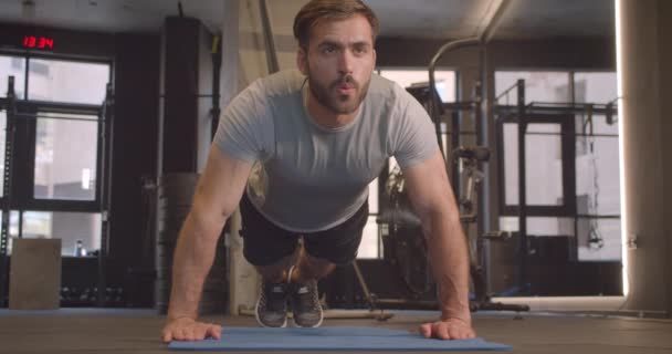 Close-up portret van volwassen aantrekkelijke sportieve Kaukasische man het maken van push-ups in de sportschool binnenshuis — Stockvideo