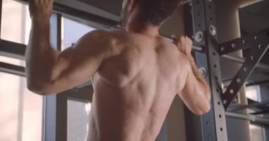 Kapalı spor salonunda barlar üzerinde çekerek yetişkin gömleksiz kas kafkas adam Closeup geri görünümü