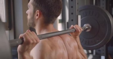 Kapalı spor salonunda gömleksiz kas kafkas adam powerlifting Closeup geri görünümü