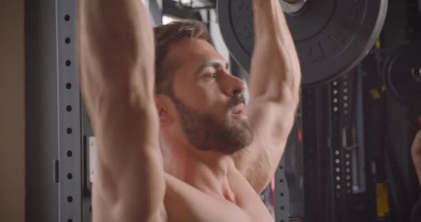 Closeup side view portrait of handsome shirtless muscular caucasian man powerlifting in the gym indoors — Stock Video