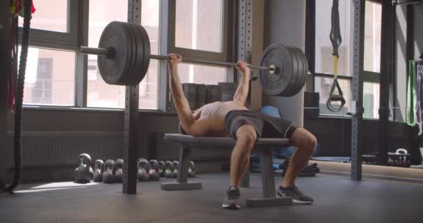 Retrato de primer plano del hombre caucásico musculoso sin camisa que pone pesas de elevación en el gimnasio en el interior — Vídeos de Stock