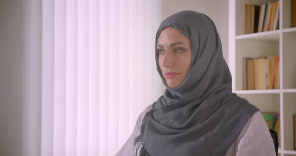 Retrato de close-up de jovem atraente mulher de negócios muçulmana no hijab olhando para a câmera sorrindo alegremente no escritório dentro de casa — Vídeo de Stock