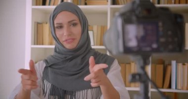 Türbanlı genç çekici Müslüman blogcu closeup portre daire içinde kapalı gesturing kamera konuşuyor