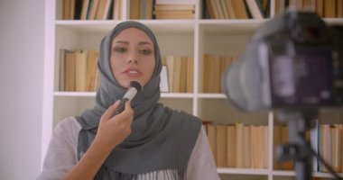 Türbanlı genç çekici Müslüman güzellik blogger'ın closeup portresi kamera makyaj ürünü inceleme kapalı yapma konuşurken