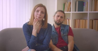 Tv'de dramatik film izleyen genç kız üzgün duygu ve evde yakın oturan erkek arkadaşı ile ağlıyor.