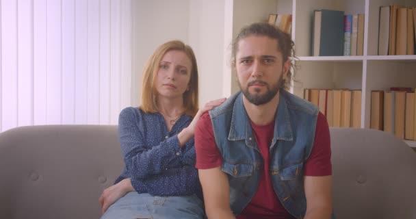 Hipster young couple watching dramatic movie on TV feeling sad and crying at home. — Stock Video