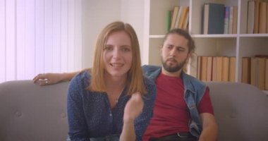Beyaz genç kız erkek arkadaşı evde yakın otururken sıkılmış iken aktif olarak takım destekler.