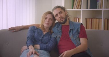 Hipster genç kafkas çift televizyonda film izlerken emilir ve evde ilgi.