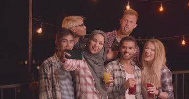 Peri ışıkları ile rahat bir akşam eğlenceli partide selfie çeken arkadaş çeşitli çok ırklı grup Closeup portre