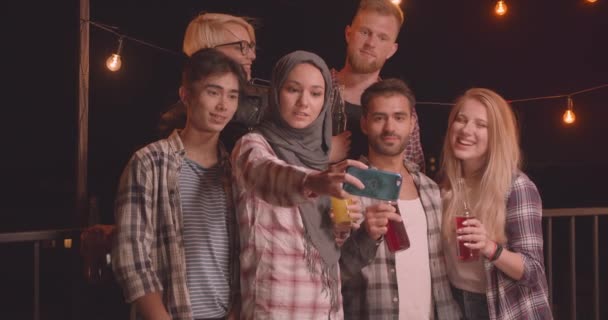 Retrato de primer plano de diversos grupos multirraciales de amigos que se toman selfies en una fiesta divertida en una noche acogedora con luces de hadas en el fondo — Vídeos de Stock