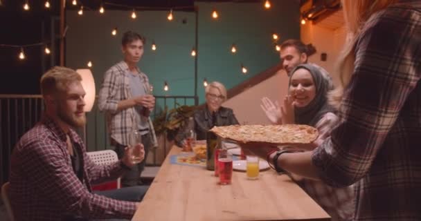 Close-up portret van diverse multiraciale groep vrienden wordt geleverd Pizza vieren op leuke feest in gezellige avond — Stockvideo