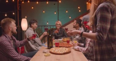 Rahat bir akşam eğlenceli partide mutlu bir şekilde içme kutlayan pizza teslim ediliyor arkadaş çeşitli çok ırklı grup Closeup portre