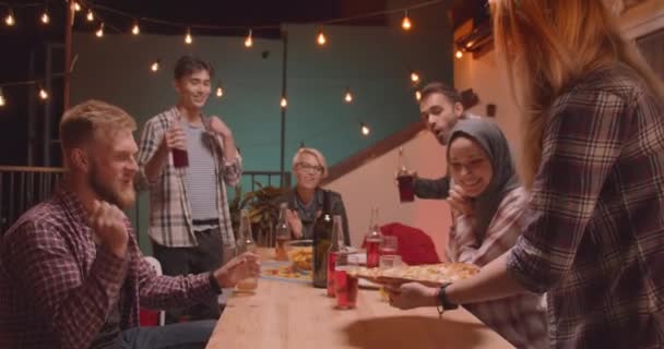 Retrato de close-up de diversos grupos multirraciais de amigos sendo entregues pizza celebrando alegremente em festa divertida à noite aconchegante — Vídeo de Stock