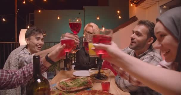 아늑한 저녁에 재미있는 파티에서 즐겁게 술을 마시는 것을 축하하는 다양한 다인종 그룹의 클로즈업 초상화 — 비디오