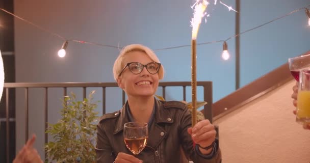 Retrato de close-up de grupo multirracial diversificado de amigos comendo pizza e bebendo vinho passando pau fogo de artifício na festa à noite aconchegante — Vídeo de Stock