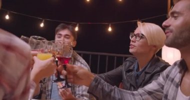 Arka planda peri ışıkları ile akşam kırmızı şarap içme ve pizza yeme arkadaş çeşitli çok ırklı grup Closeup portre