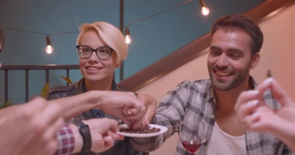 Close-up portret van diverse multiraciale groep vrienden eten Chinees eten in de avond met Fairy lichten op achtergrond — Stockvideo