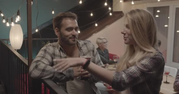 Close-up portret van aantrekkelijke paar staande flirten praten gelukkig met diverse groep vrienden op achtergrond op partij — Stockvideo