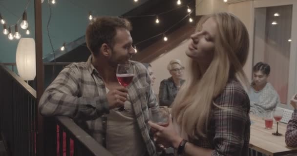 Close-up portret van aantrekkelijke Kaukasische paar staande flirten praten gelukkig met diverse groep vrienden op achtergrond op partij — Stockvideo