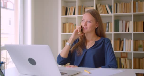 Close-up retrato de jovem bem sucedido atraente mulher de negócios caucasiana usando laptop ter telefonema ficando animado no escritório dentro de casa — Vídeo de Stock