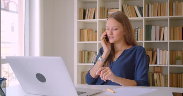 Primer plano retrato de joven exitoso atractiva mujer de negocios caucásica utilizando portátil que tiene llamada telefónica siendo infeliz en la oficina en el interior — Vídeos de Stock