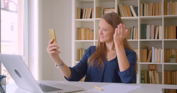 Closeup portré fiatal vonzó kaukázusi üzletasszony vesz selfies telefonon ülve előtt laptop hivatalban beltéri — Stock videók