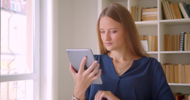 Closeup portrét mladé kavkazské obchodženské s tabletem a zobrazující zelenou obrazovku Chroma s fotoaparátem, který sedí u stolu v kanceláři — Stock video