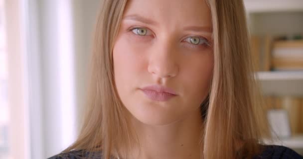 Genç güzel beyaz kızın kapalı dairede kameraya bakan closeup portresi — Stok video