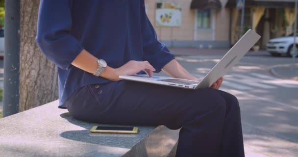 Close-up vista lateral retrato de jovem atraente mulher de negócios caucasiana digitando no laptop no parque ao ar livre na cidade urbana — Vídeo de Stock